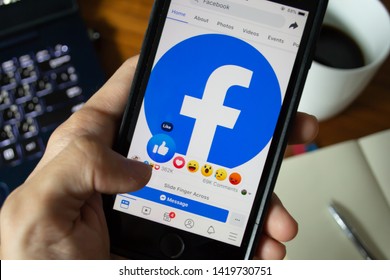 Bangkok, Thailand - June 9, 2019 : Facebook user touch on Like button in Facebook application on iPhone 7.