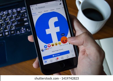 Bangkok, Thailand - June 9, 2019 : Facebook user touch on Angry button in Facebook application on iPhone 7.
