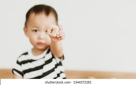 BANGKOK, THAILAND - MARCH 05, 2019: Little asian baby boy holding Facebook logo on wooden block.Concept for social media and protection child in social media.