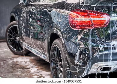 BANGKOK, THAILAND - MARCH 16, 2019: Mercedes Benz taillight & rear fender covered with washing foam & soap. Professional car detailing & commercial cleaning service concept. Car wash background. - Shutterstock ID 1349087531