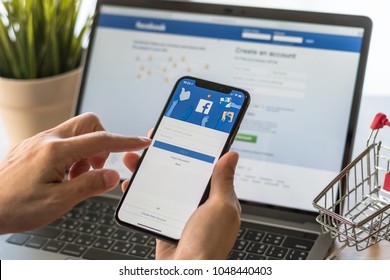 BANGKOK, THAILAND - March 18, 2018: Facebook social media app logo on log-in, sign-up registration page on mobile app screen on iPhone X (10) in person's hand working on e-commerce shopping business
