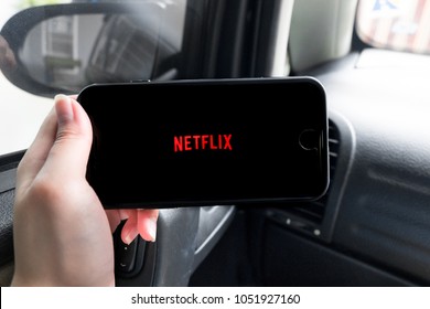 Bangkok, Thailand - March 22, 2018: Netflix And Chill, Woman Hand Holding IPhone Screen Showing Netflix Logo In A Car