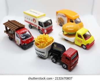 Bangkok, Thailand - March 3, 2022: A set of 5 food trucks (ramen, fries, bread, burger and curry rice trucks) on the white background. Tomica is a famous Japanese brand of toy car model.