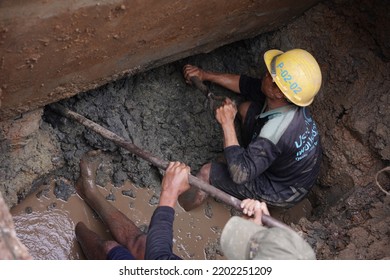 BANGKOK, THAILAND – MAY 04, 2022 : Water Supply Government's Workers Are Digging Wet Soil From Underground In Repairing Broken Pipe And Flood Problem. Underground Infrastructure Maintainace.