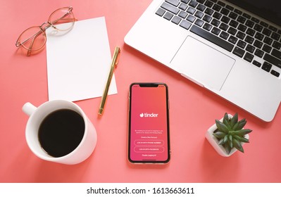 BANGKOK, THAILAND - May 17,2019: Flat lay of workspace desk and Apple iPhone XS with Tinder application on the screen. Tinder is a dating mobile app