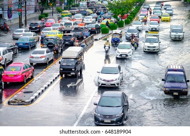 Bangkok, Thailand - May 27, 2017: Thai flood hits Central of Thailand, higher water levels expected, cars navigating through the flood