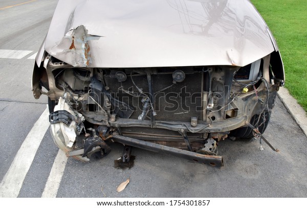 BANGKOK, THAILAND - May 28, 2020 : Car crashed\
from the accident on the road. Parked in the thick grass in front\
of the police station.