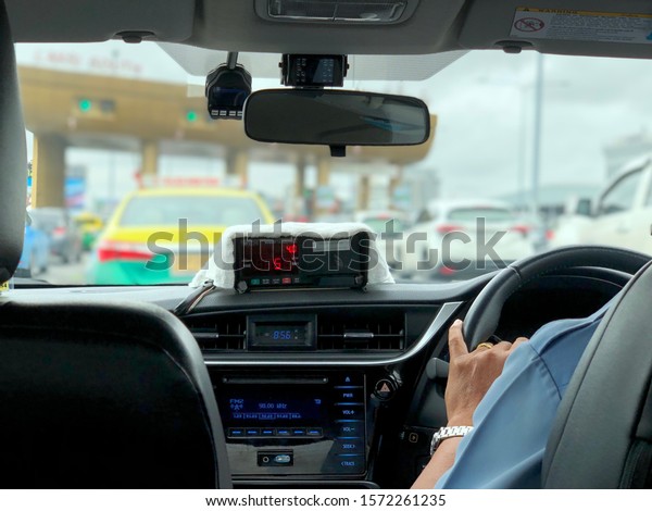 BANGKOK, THAILAND, NOV 20,\
2019: The taxi driver is waiting to enter the express way ticket\
booth.