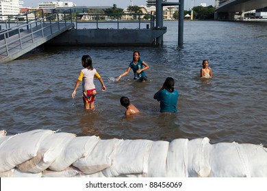 BANGKOK, THAILAND - NOVEMBER 04: unidentified Children swimming at a sandbag wall at the Chao Phraya river on November 04, 2009 in Bangkok, Thailand. During Thailand's worst monsoon flood in 20 years