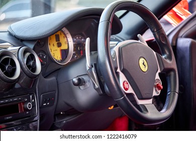 BANGKOK, THAILAND - NOVEMBER 1, 2018: Red Ferrari F430 is Italian sports car. Selective focus of cockpit interior with steering wheel and yellow speedometer  background. Classic supercar wallpaper