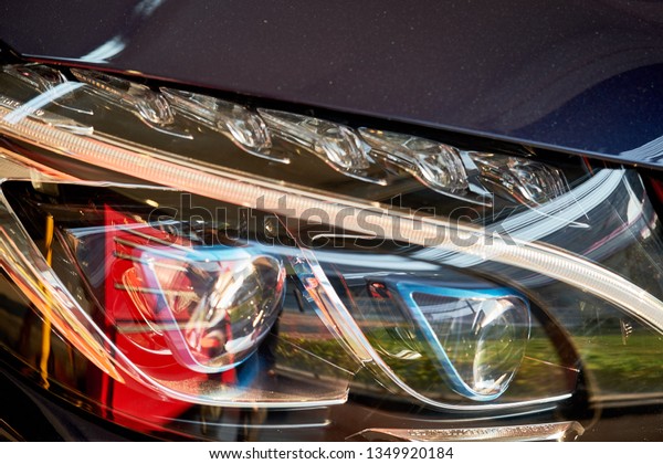 BANGKOK, THAILAND - November 19, 2018: Close up of\
Mercedes Benz C350e headlight detail. Reflection on shiny sedan\
headlamp in front of vehicle. Concept of lens & LED projector\
design of luxury car.