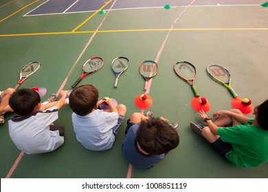 BANGKOK, THAILAND - NOVEMBER 22, 2012: In a college in Bangkok, school children take an outdoor tennis lesson.