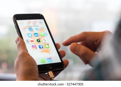 BANGKOK, THAILAND - NOVEMBER 26, 2016: Man Using Iphone7 Plus Jet Black Series With Application Icons Of Social Media On Screen