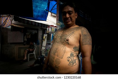 Bangkok / Thailand - November 7th 2018: Ban Bat Community.  A Man In A Dark Alley, With Numerous Traditional Sak Yant  Tattoes