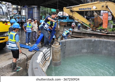 BANGKOK, THAILAND - OCT 16, 2013: Workmen carry out maintenance on a storm drain on a city centre street. The Thai capital has a widespread storm drain network to manage monsoon rains. 