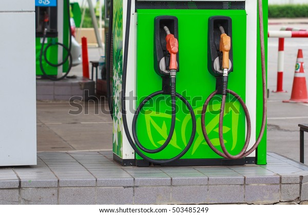 Bangkok Thailand - Oct 16th, 2016:\
yellow and red petrol oil pump nozzles in a service station\
background green,Fuel nozzle in oil station bangchak\
Thailand