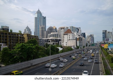 BANGKOK, THAILAND - OCT 9, 2022 : Highrise Building And Highway Road With Many Vehicles In Bangkok Area. View From Green Bridge Or Lumphini-Benchakitti Park Walkway.