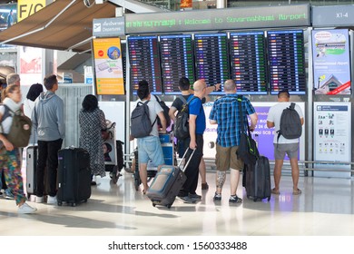 Bangkok, Thailand - October 13, 2019: International Airport Suvarnabhumi People Look At Flight Schedule Screen, Passengers Near Display Board, Airplanes Departure Or Arrival Time And Gate Information 