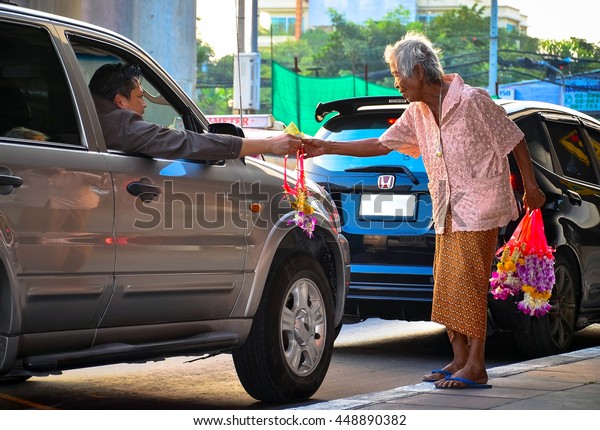 BANGKOK THAILAND - OCTOBER\
15,2014: An old woman sell a lot of flowers beside the street who\
don\'t give up with her life,Jaransanitwong road in Bangkok\
,Thailand