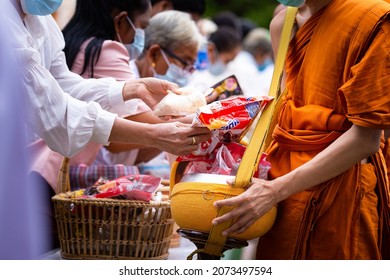 Bangkok, Thailand October 22 2021: Alms Offering Ceremony on the Buddhist Lent Day of Buddhists in Thailand making merit with flowers and dry food;Thai Buddhist to do good things make merit by offer.