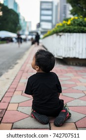 BANGKOK, THAILAND - OCTOBER 26, 2017: Young thai boy kneeling while in line to pay his last respect to the beloved Majesty, the late King Bhumibol Adulyadej at Lumpini Park in the afternoon