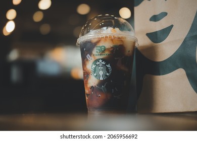 Bangkok, Thailand - October 29, 2021 : Yuzu Cold Brew in a reusable cup with a special 50th anniversary design at Starbucks cafe, Starbucks is the world largest coffee house.