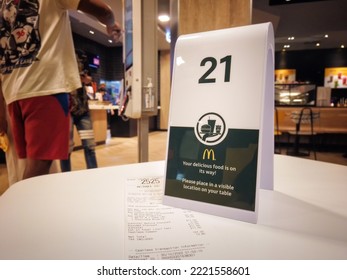 BANGKOK, THAILAND - October 30, 2022: Order Number Along With A Purchase Receipt Awaits For Food Preparation In Mcdonald's Fast Food Restaurant