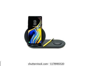 Bangkok, Thailand - Sep 12, 2018: Studio shot of new Samsung Galaxy Note 9 smartphone with S pen on wireless charger duo, fast charge accessory, isolated on white background. Illustrative editorial