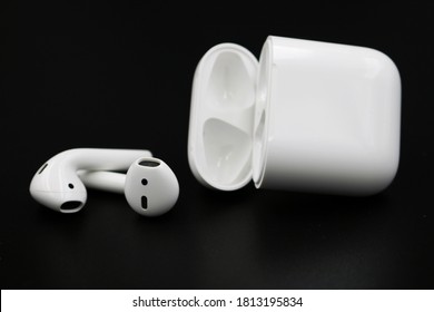Bangkok, Thailand - Sep 12,2020 : Air Pods. with Wireless Charging Case. New Airpods 2019 on black background. Airpods.EarPods.low lighting.