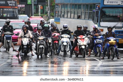 BANGKOK, THAILAND - SEP 25, 2013: Motorcyclists wait at a busy junction during a rainy rush hour. Motorcycles are often the transport of choice on the heavily congested roads of the Thai capital.