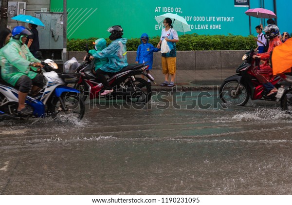 BANGKOK, THAILAND - SEPTEMBER 20, 2018 : Heavy\
rain in Bangkok, Thailand. effect of raining on the road, Flooding\
at Bangna, Bangkok. car splashes through a large puddle on flooded\
street.