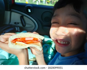 Bangkok, Thailand - September 22 2020 : Asian Boy Eating Sandwich In The Car. 