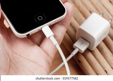 BANGKOK, THAILAND - SEPTEMBER 23, 2015: The iPhone5C connecting with the charger cable.
