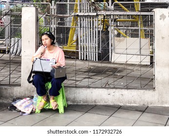 BANGKOK, THAILAND, SEPTEMBER 6, 2018: The Blind Teenage Thai Girl Who Is Beggar Is Singing Some Popular International Songs To Get Money From The Tourists At The Train Station.