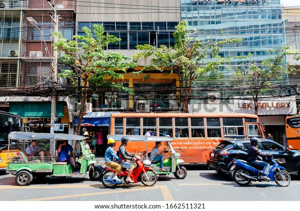 BANGKOK, THAILAND: Urban city traffic with cars,\
buses, tuk-tuk taxis, motorbikes driving through asian streets on\
February 21, 2020. More than 12,000,000 foreign tourists visit\
Bangkok every year