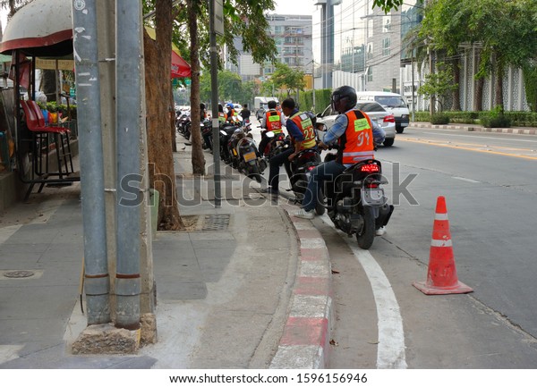 Bangkok,\
Thailand-December 23, 2019 : Group of motorcyclists get ready on\
pillions waiting for passengers at motorcycle taxi queue. Traveling\
by motorbike taxi is popular in\
Bangkok.