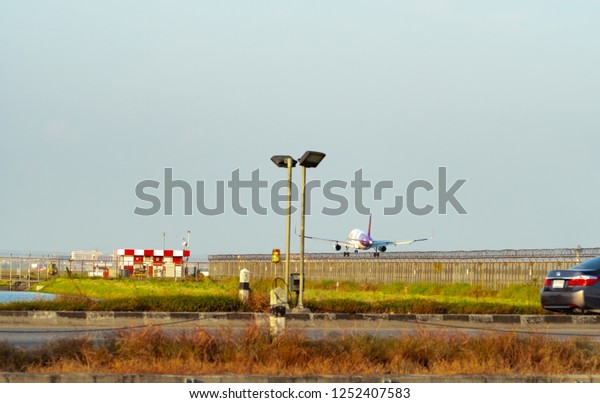 BANGKOK,\
THAILAND-DECEMBER 3, 2018 : Thai Smile Airways. Passenger plane is\
landing at Suvarnabhumi Airport in Thailand. Airbus A200. Fence and\
solar cell panels at the\
airport.
