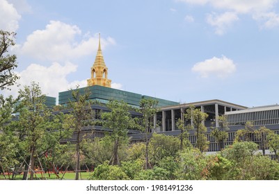 Bangkok, THAILAND-May19, 2021: NEW PARLIAMENT with GOLDEN PAGODA of ROYAL KINGDOM of THAILAND behind green garden. The new attractive landmark of the capital city.
