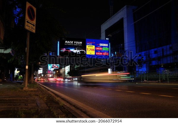BANGKOK, THAILAND-OCTOBER 26,2021: LED Billboard\
screen at night time, The daily charge reported COVID-19 infections\
are decreasing in Thailand, with 7,706 new infections reported on\
average each day.
