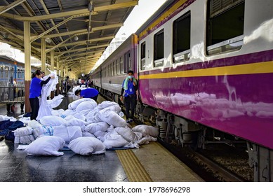 Bangkok Train Station – March 20, 2021: Sacks Of Soiled Linens From The Sleeper Terrain Piled Up On The Platform Floor Being Sorted Out By Laundry Workers Before Sending For Cleaning.