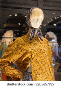 Bangkok-Sep.22 2022: Urban Nomad Haute Couture Store On The Second Floor Of The Central World Mall.  A Girl Model Wearing A Yellow Printed New Style Trench Coat With A Blue Printed European Turban.