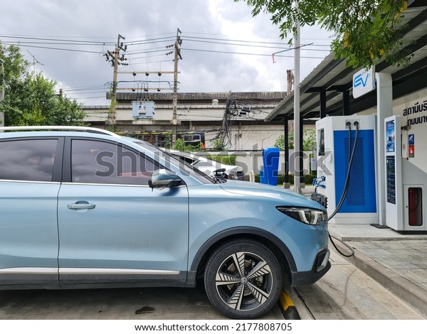 Bangkok,Thailand 10 July 2022:Modern\
electric car (EV Car) plugged in charging on the street station.\
New energy vehicles, eco-friendly alternative energy for\
cars\
\
