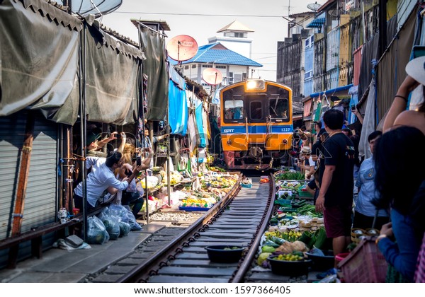 BANGKOK,THAILAND\
- DECEMBER 11, 2016: Train drives through a market and very close\
to the merchants and merchants and\
goods