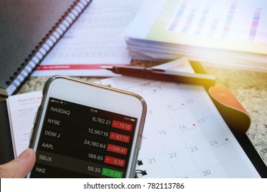Bangkok-Thailand, December 2017 : Business concept of Hand holding smartphone on blurred messy business papers on working desk closeup background