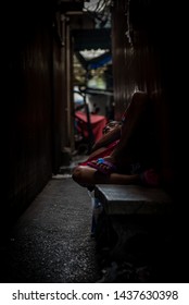 Bangkok/Thailand - Feb 05-02-19 - Mature Thai Man Resting In A Narrow Dark Alley In The Middle Of The Center Of Bangkok.