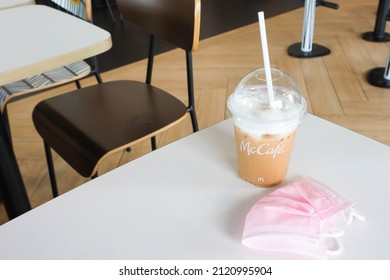 BANGKOK,THAILAND - JANUARY 20,2022 : Mcdonald's Coffee Cup On Wooden Table At McDonald's Restaurant.