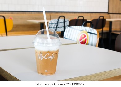 BANGKOK,THAILAND - JANUARY 20,2022 : Mcdonald's Coffee Cup On Wooden Table At McDonald's Restaurant.