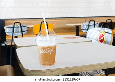 BANGKOK,THAILAND - JANUARY 20,2022 : Mcdonald's Coffee Cup On Wooden Table At McDonald's Restaurant.