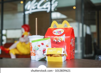 BANGKOK,THAILAND - JANUARY 9,2018 : Happy Meal Set On Desk ,in Soft Focus, With Blurred Ronald McDonald At McDonald's Restaurant