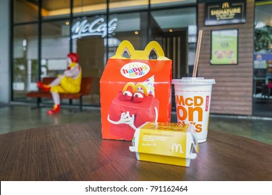 BANGKOK,THAILAND - JANUARY 9,2018 : Happy Meal Set On Desk ,in Soft Focus, With Blurred Ronald McDonald At McDonald's Restaurant On 